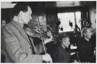 Mahtra Talurahvamuuseumi  kapel. Esiplaanil viiuliga Johannes Ausmees