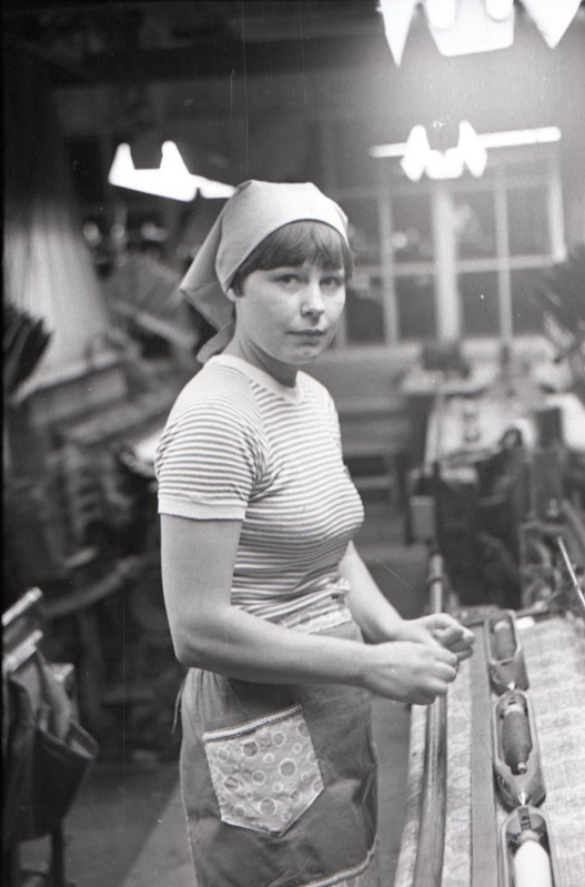 Komnoorte laupäevak kudumisvabrikus, naine seisab masina juures