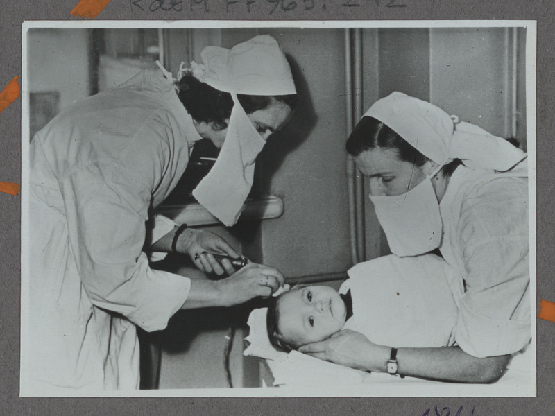 Eesti raudtee: Tallinna Raudteelaste Lastehaigla vanem-meditsiiniõde Irene Kikas süstib aastast patsienti Galjat, 1959, foto: Oskar Sildam