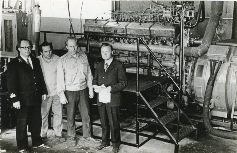 Tallinna veduridepoo ühiskondliku konstrueerimisbüroo liikmed enda konstrueeritud VME1 vedurite diiselmootorite katsestendi ees, vasakult esimene depoo peainsener Vadim Kiritšenko, 1. juuli 1975, foto: Mihkel Ollino