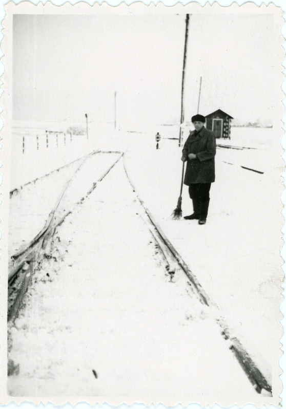 Talvine vaade Haapsalu jaama merepoolsetele teedele pöörmeposti nr 2 lähedal, jaamatöötaja luuaga, 1950.-1960. aastad
