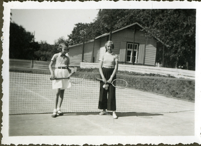 Niina Nurslandt sõbrannaga Kuressaare tenniseväljakul reketitega poseerimas.