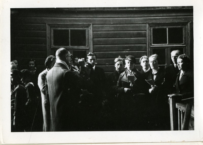 Grupp gümnasiste  Aleksander Friedrich Allikut tema 70. sünnipäeval õnnitlemas. Tervituslaul Joosep Aaviku juhatusel. 1938.a.