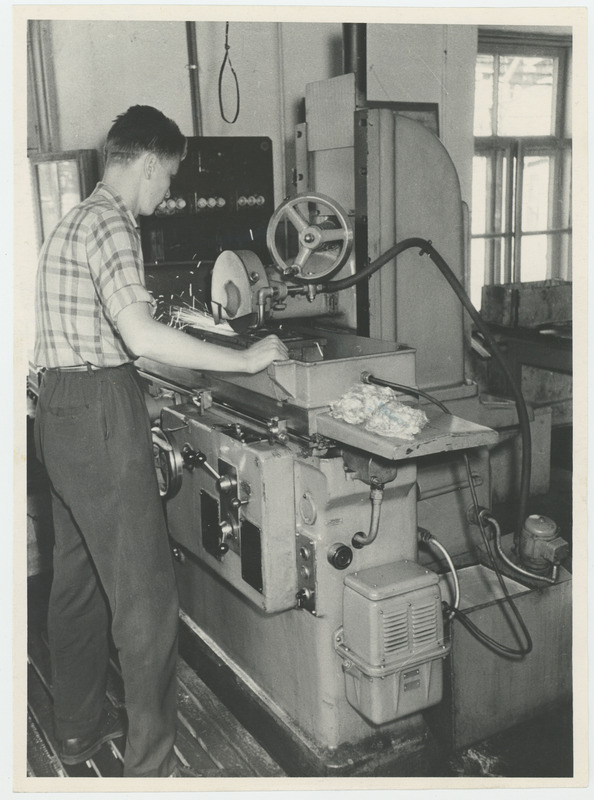 Tööline lihvimispingi taga.