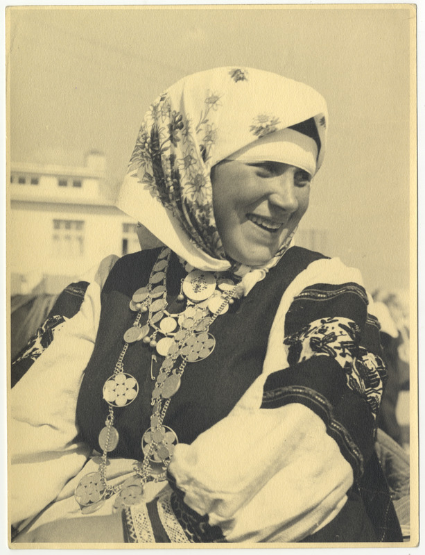 Rätikuga setu rahvariietes naine, hulga rahadega rist kaelas.