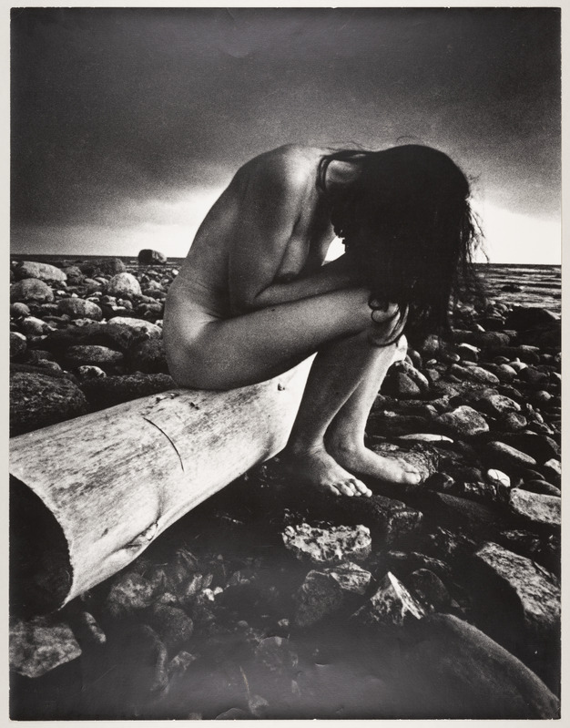 Kivisel rannal palgil istuv akt