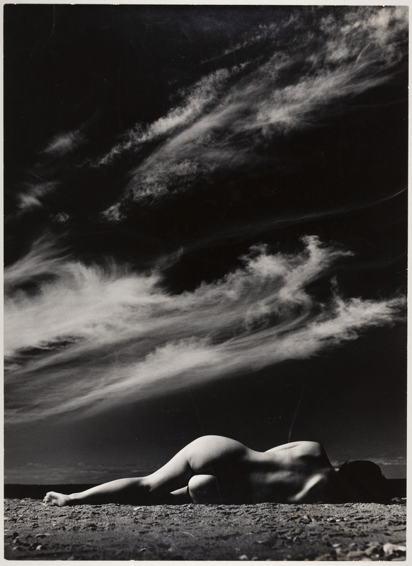 Taevas ja rannas küljel lebav akt.