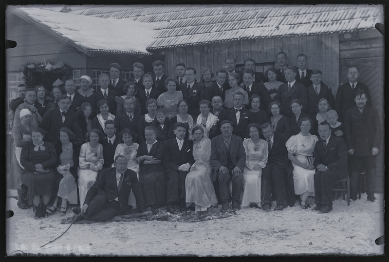 Grupiportree: pruutpaar Arko ja Herta Pääsuke (istuvad ees kesekl) pulmakülalistega fotograafile poseerimas.