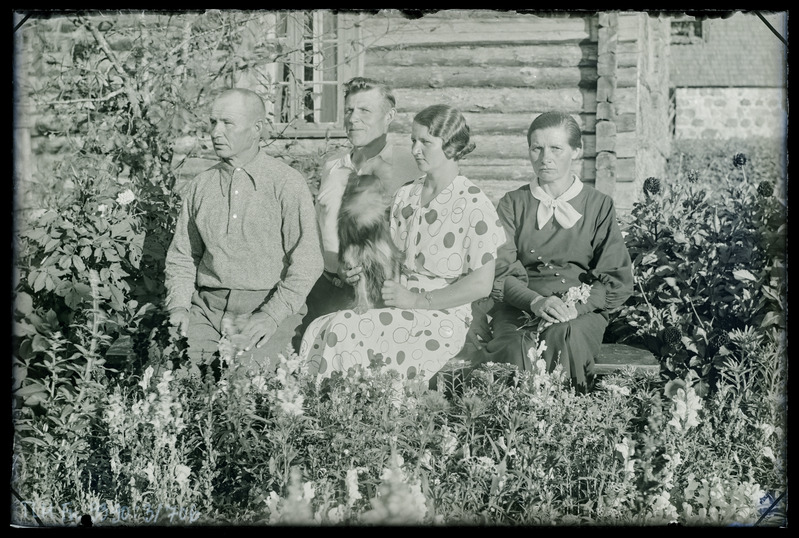 Grupiportree: tundmatud, kaks meest ja kaks naist, talu aias istumas.