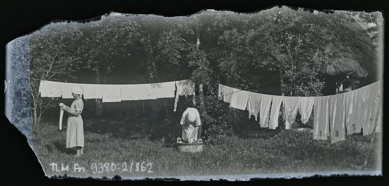 Vaade: kaks tundmatut naist pesu nöörile kuivama panemas