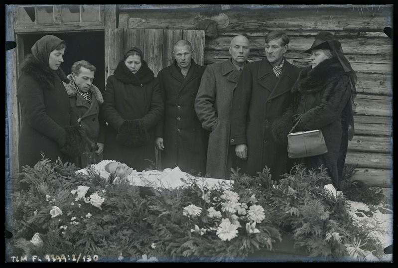 Grupipilt: matuselised kirstu juures