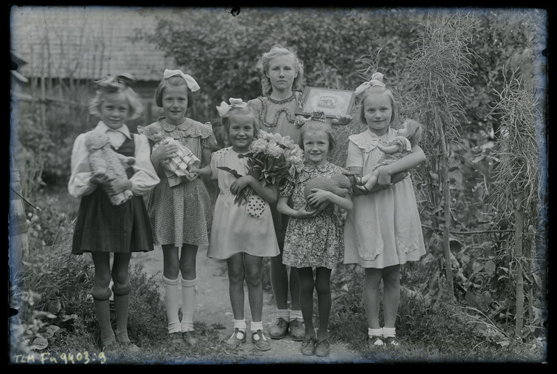Grupipilt: 6 tüdrukut lillede ja mänguasjadega