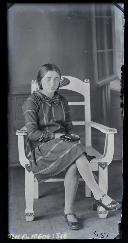 Täisportree: tundmatu naine istumas toolile raamatuga