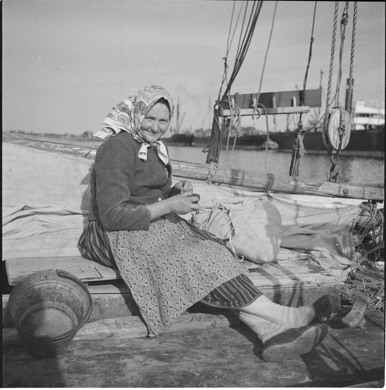 Portree: naine Kihnu rahvariietes laevatekil istumas