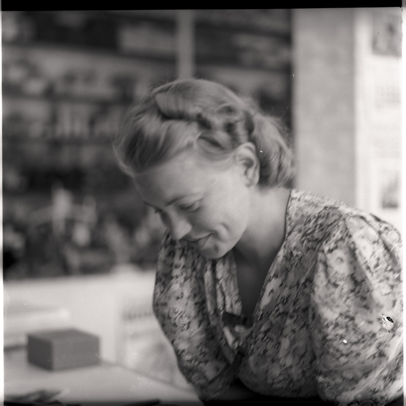 Portree: noor naine, tagaplaanil poeriiulid