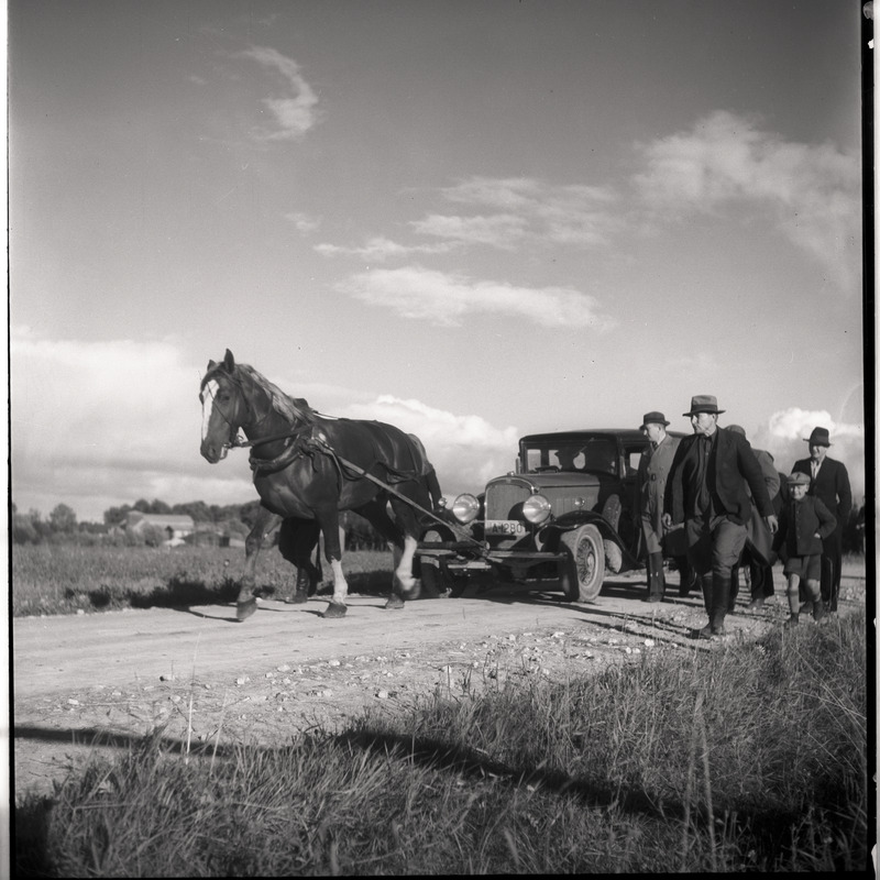 Hobune sõiduautot vedamas, inimesed kõrval kõndimas