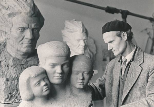 Skulptor Endel Taniloo oma ateljees lõpetamas kolmikskulptuurportreed. Vasakul ja taga Juhan Simmi skulptuurportreed. Tartu, 1962.
