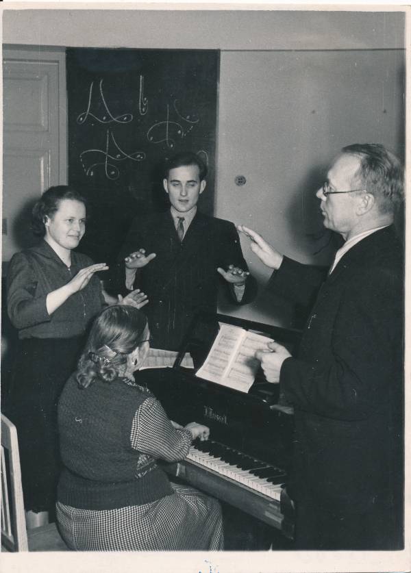 Tartu Muusikakursused, osavõtjad. Otsevaates seisavad Juta Kajo ja Heino Kallas, klaveril saadab kontsertmeister Amanda Parv, paremal dirigent ja helilooja Richard Ritsing. 1957