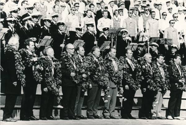 Tartu juubelilaulupidu, lauljad ja pillimehed laval. Ees dirigendid, tammepärjad kaelas. 1969