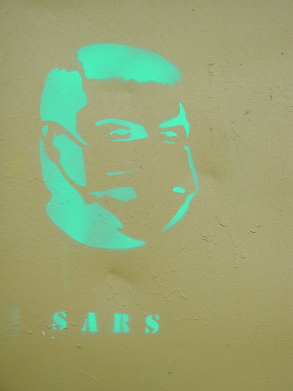 Digifoto. Grafiti: kaitsemaskiga mees, juures kiri SARS. Tartu, 2004.