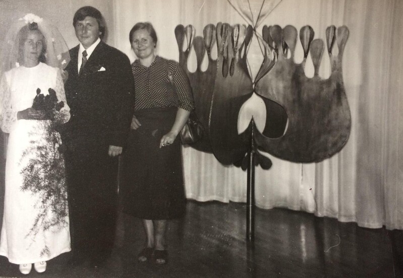 Digitaalne kujutis. Tartu perekonnaseisuamet, pulmapilt. Pruutpaar Viive ja Toomas Nummert ning kunstnik Siiri-Merike Nummert oma metalltaiese „Armuõis“ kõrval. 1975