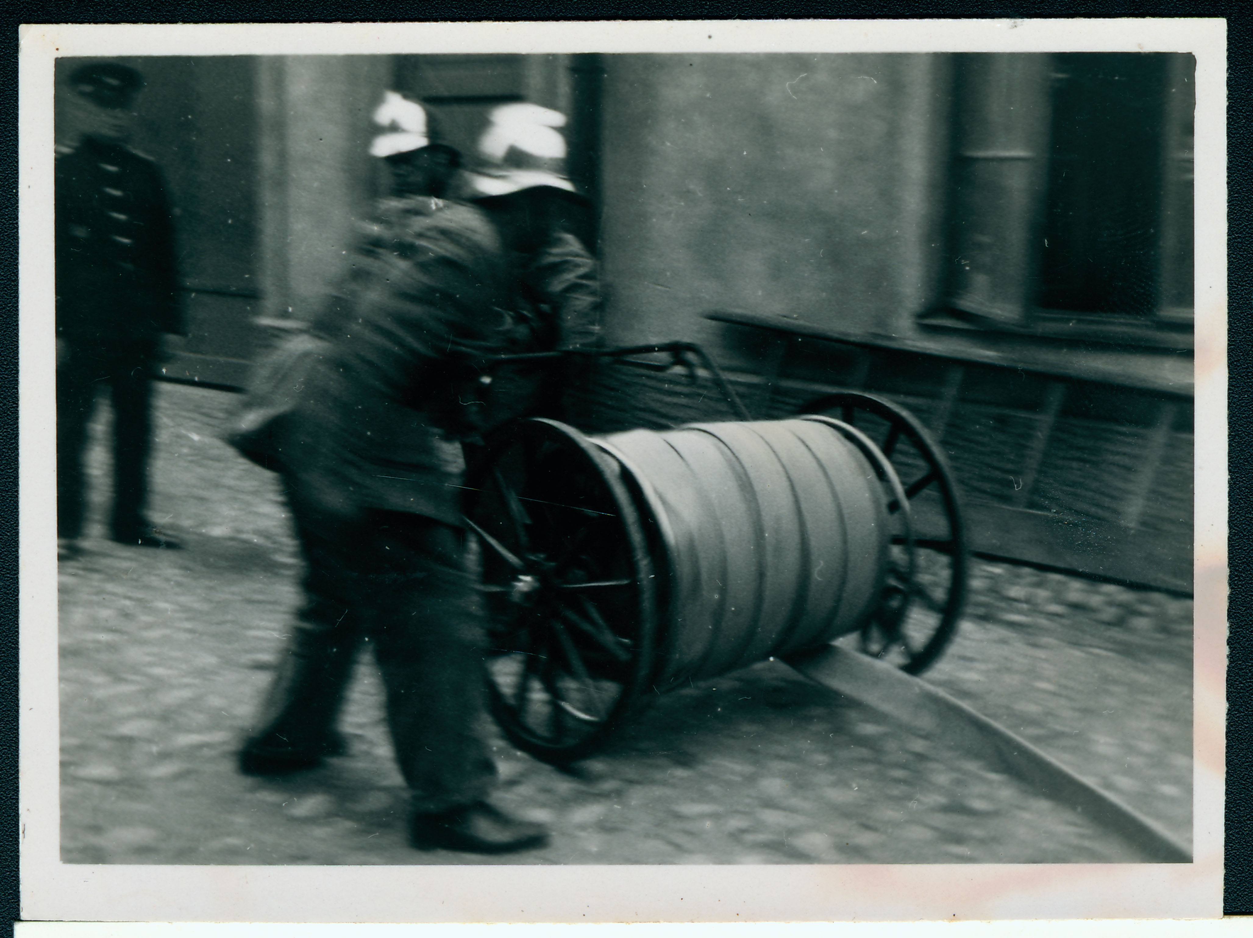 Kaks tuletõrjujat käruvärtent vedamas.