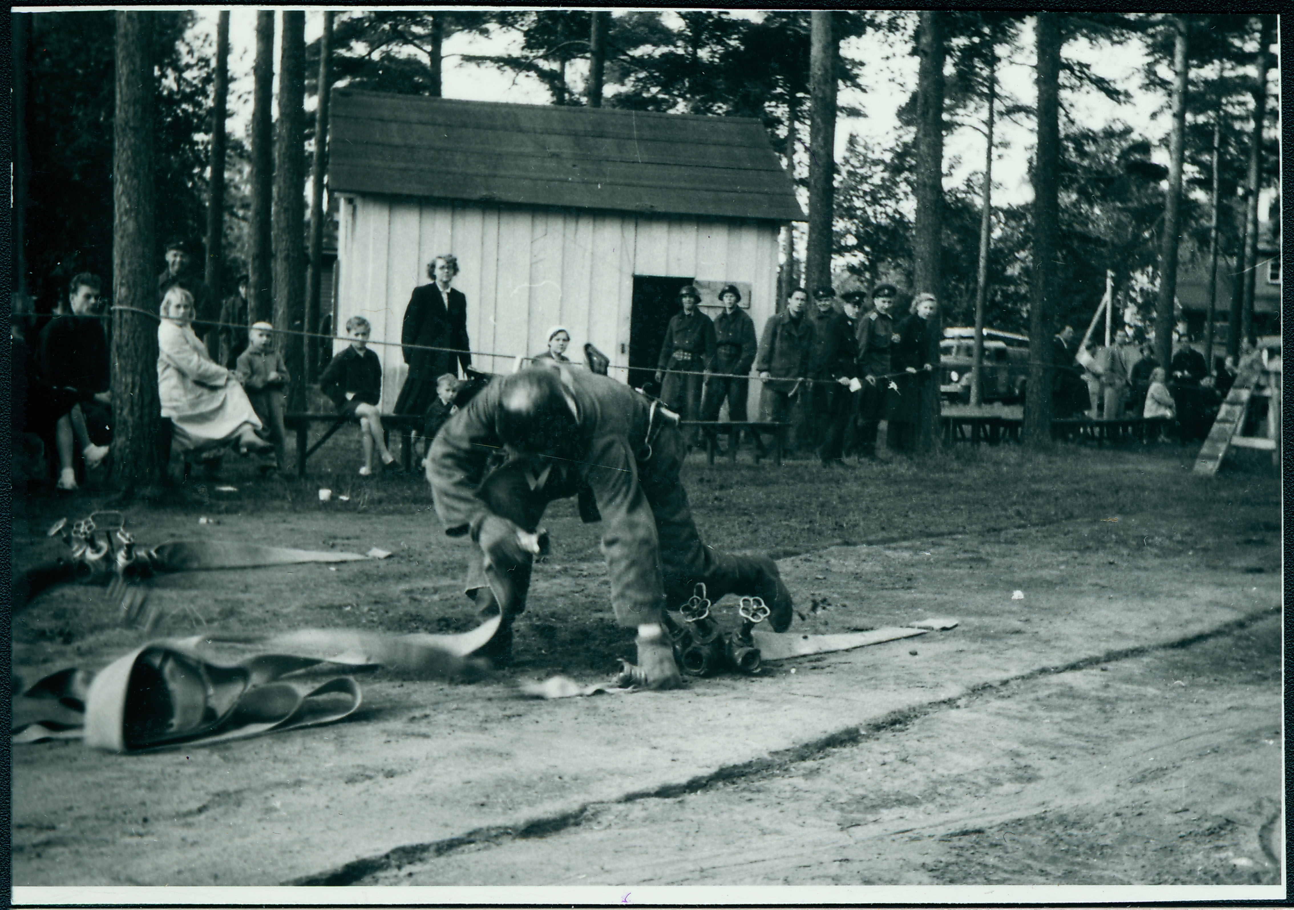 Tallinna, Tartu ja Pärnu kutseliste tuletõrjeüksuste tuletõrjespordivõistlustel: takistusribal voolikute ühendamine, 1958.a.