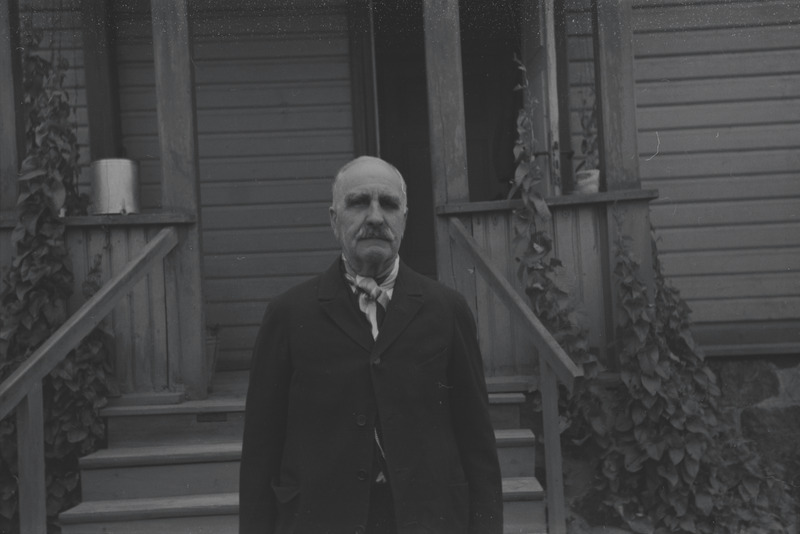 Vanem mees maja taustal