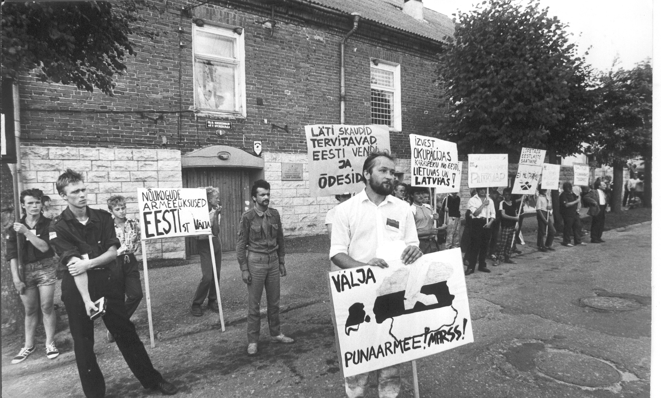 Foto. 26.juulil 1988.a.VSK nr.1 pikett sõjakomissariaadi ees ,plakatiga Riho Nassar