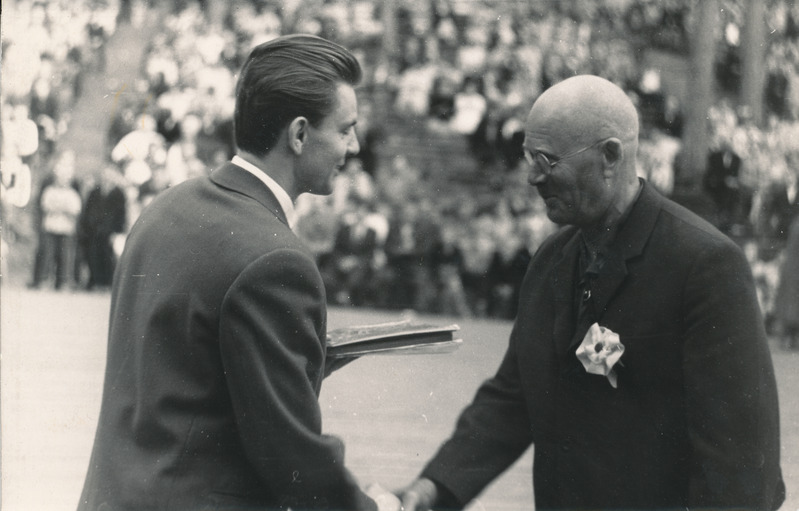 Foto. Võru rajooni  1963.a. laulupeol Ilmar Kudu, Võru kultuuriosakonna juhataja, autasustab Tartu dirigent Rohtlat.