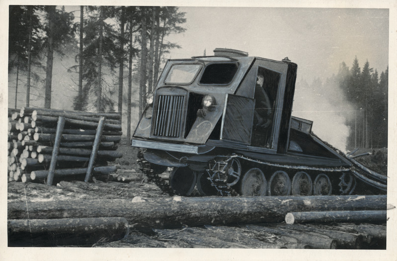 Foto. Võru Metsatööstuskeskuse võimas metsaveotraktor laasitud tüvesid estakaadille vedamas.