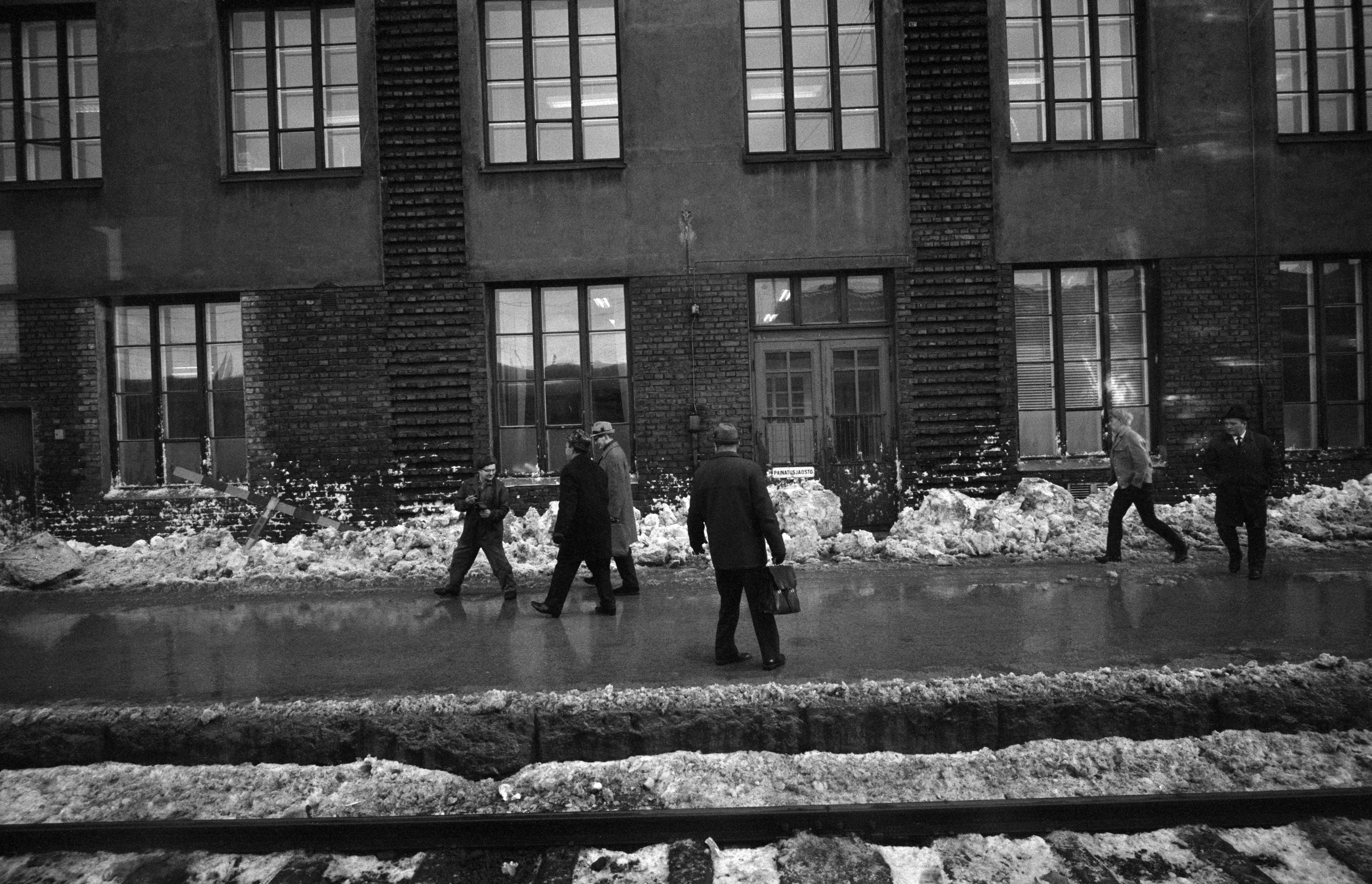 Ihmisiä loskaisella asemalaiturilla Helsingin Rautatieasemalla junan ikkunasta kuvattuna. Talvi 1970.