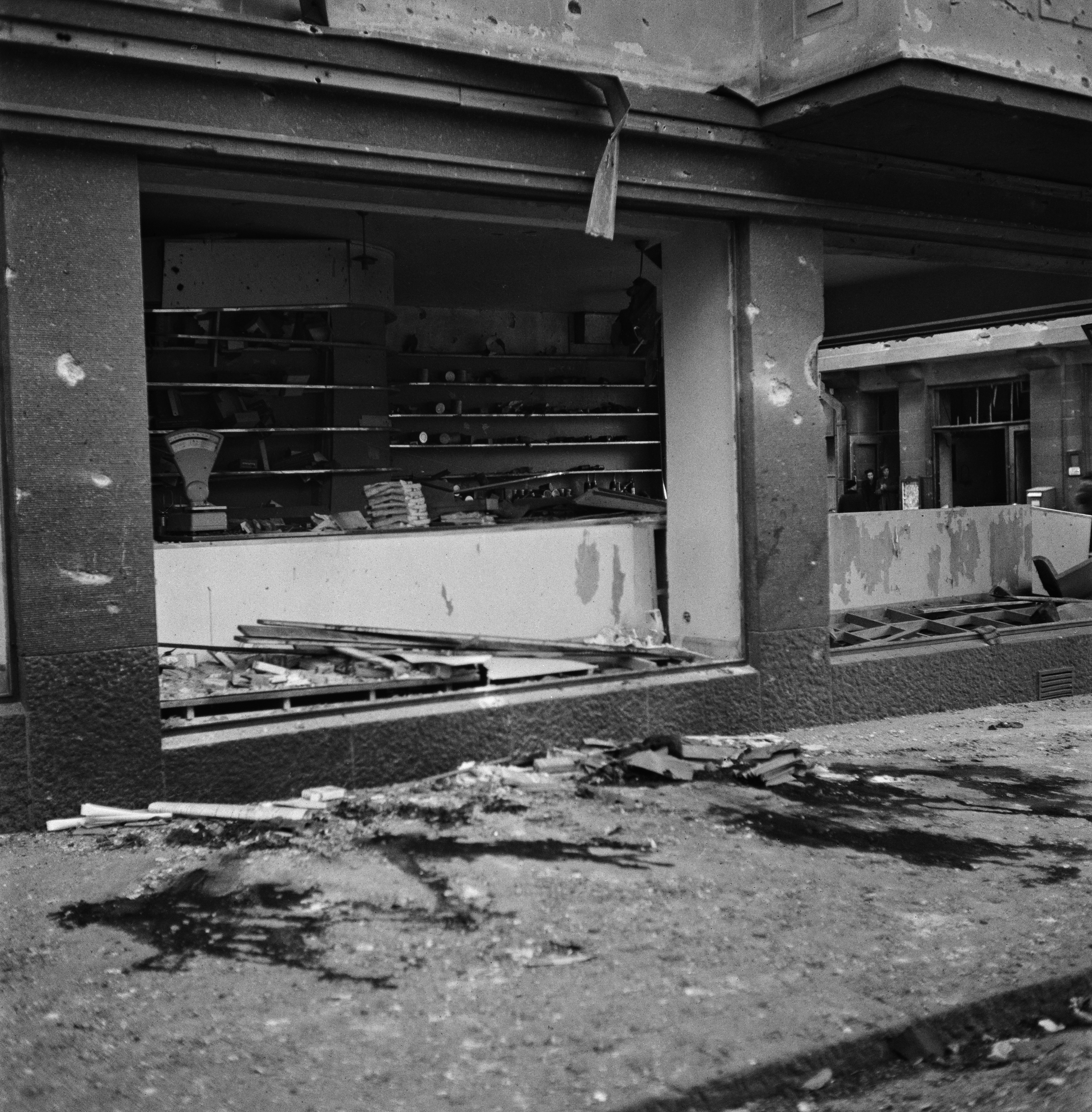 Pommitusten tuhoja Helsingin keskustan alueella. Pahasti vaurioitunut liikehuoneisto. Yrjönkatu 4. Verta kadulla. Vain yksi pommi putosi kadulle. 51 kuolinuhria.