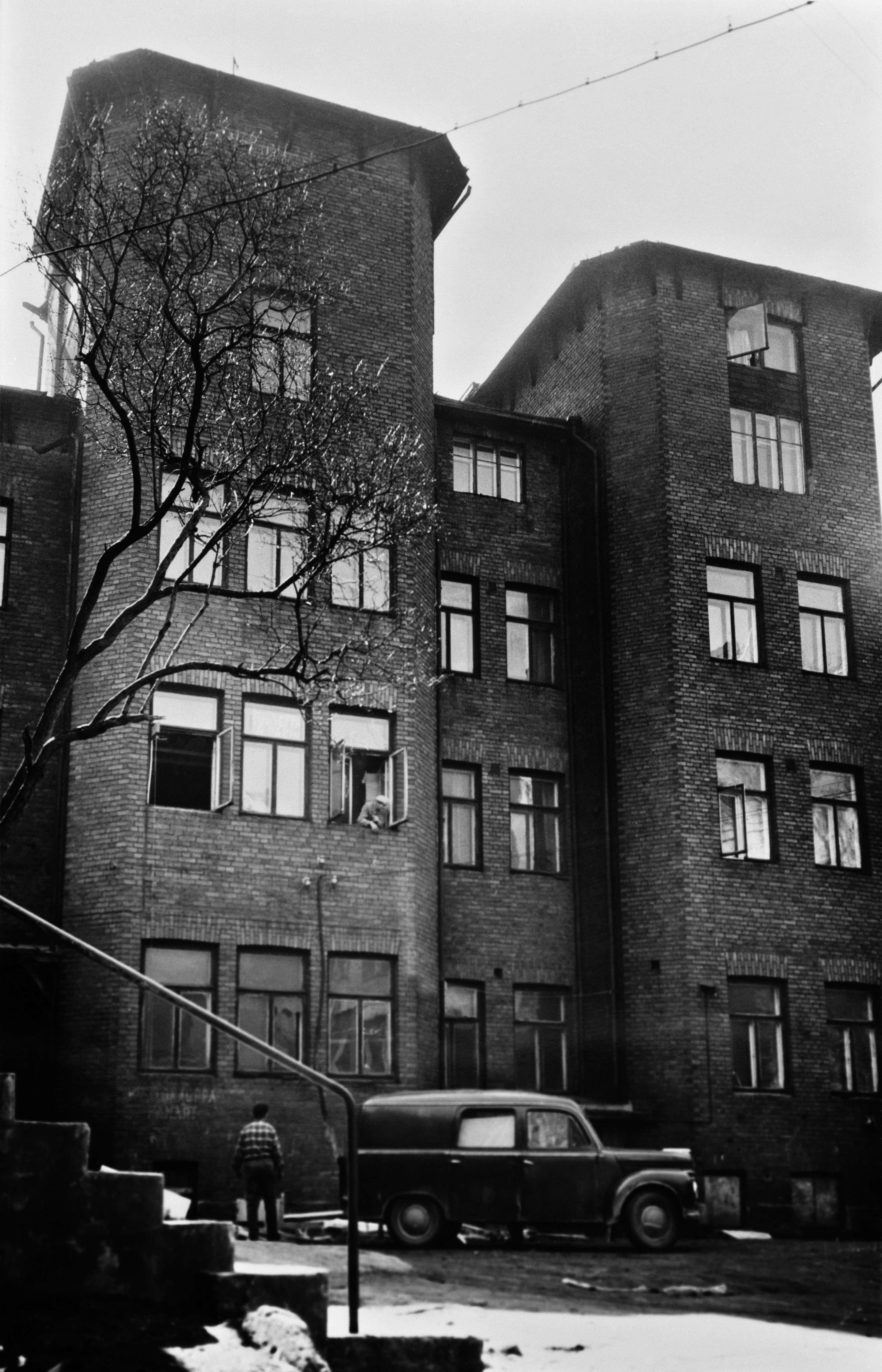 Annankatu 8 pihan puolelta. Tiilitalon seinää ikkunoineen, pihassa pakettiauto.Talo on As. Oy Annanlinnan kuvausvuonna 1960 valmistunut talo.