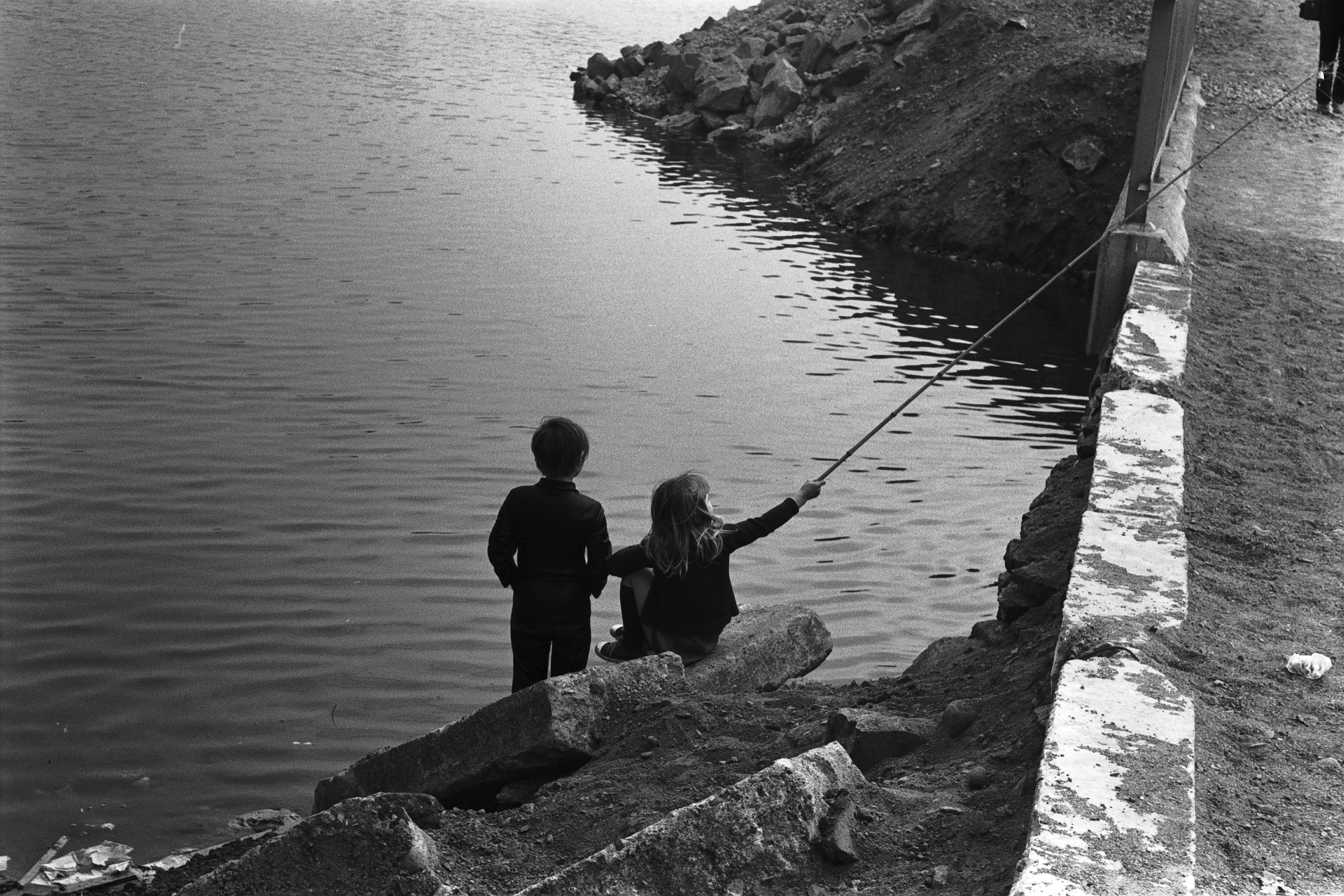 Tokoinranta. Kaksi lasta ongella pääradan laidalla pienen sillan kupeessa Eläintarhanlahden luoteisrannalla.