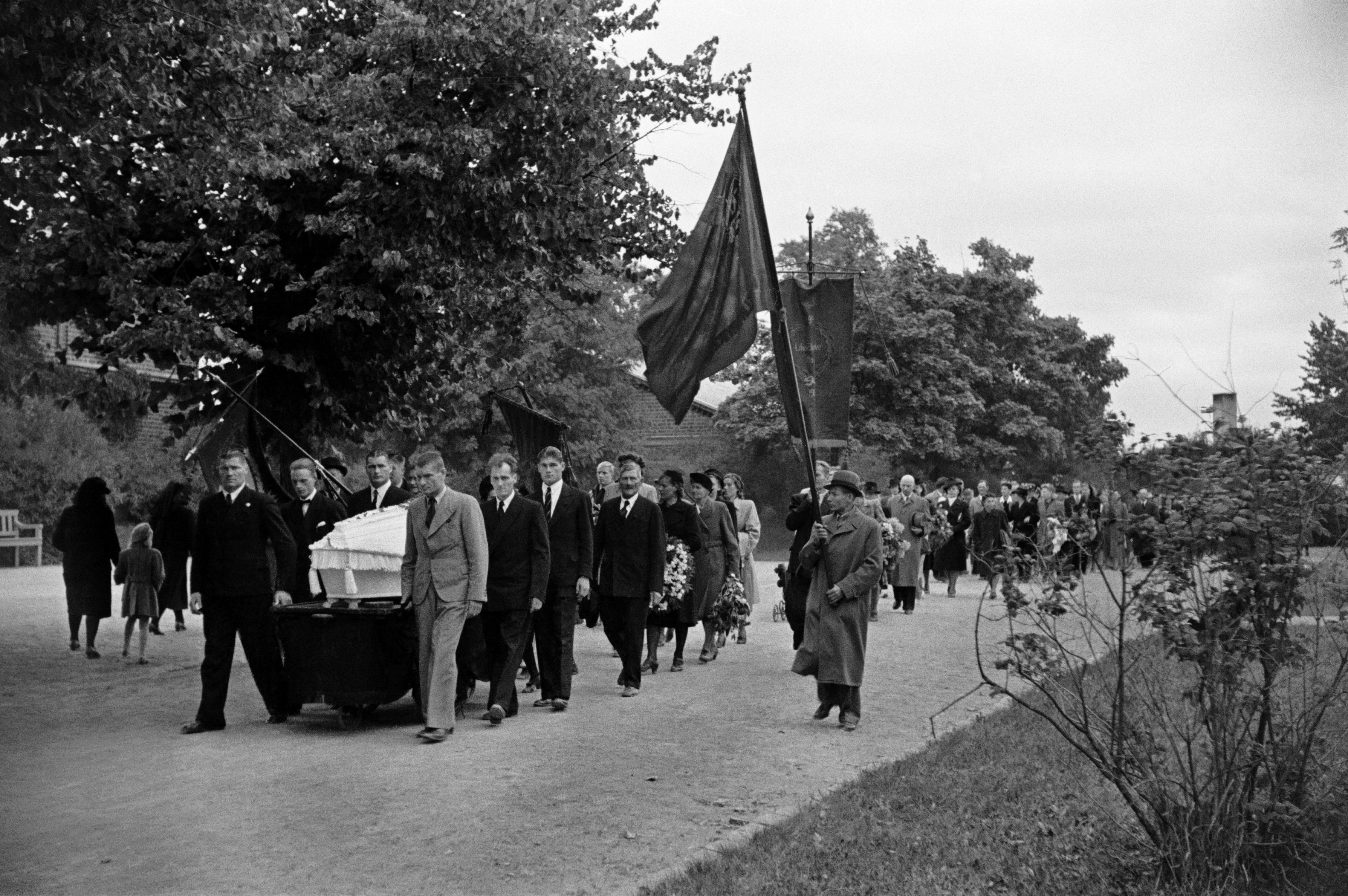 Pohjoinen hautausmaa (=Malmin hautausmaa), Arvi Heinon hautajaiset. Hautasaatto, miehet kantavat ammattiyhdistysten lippuja.