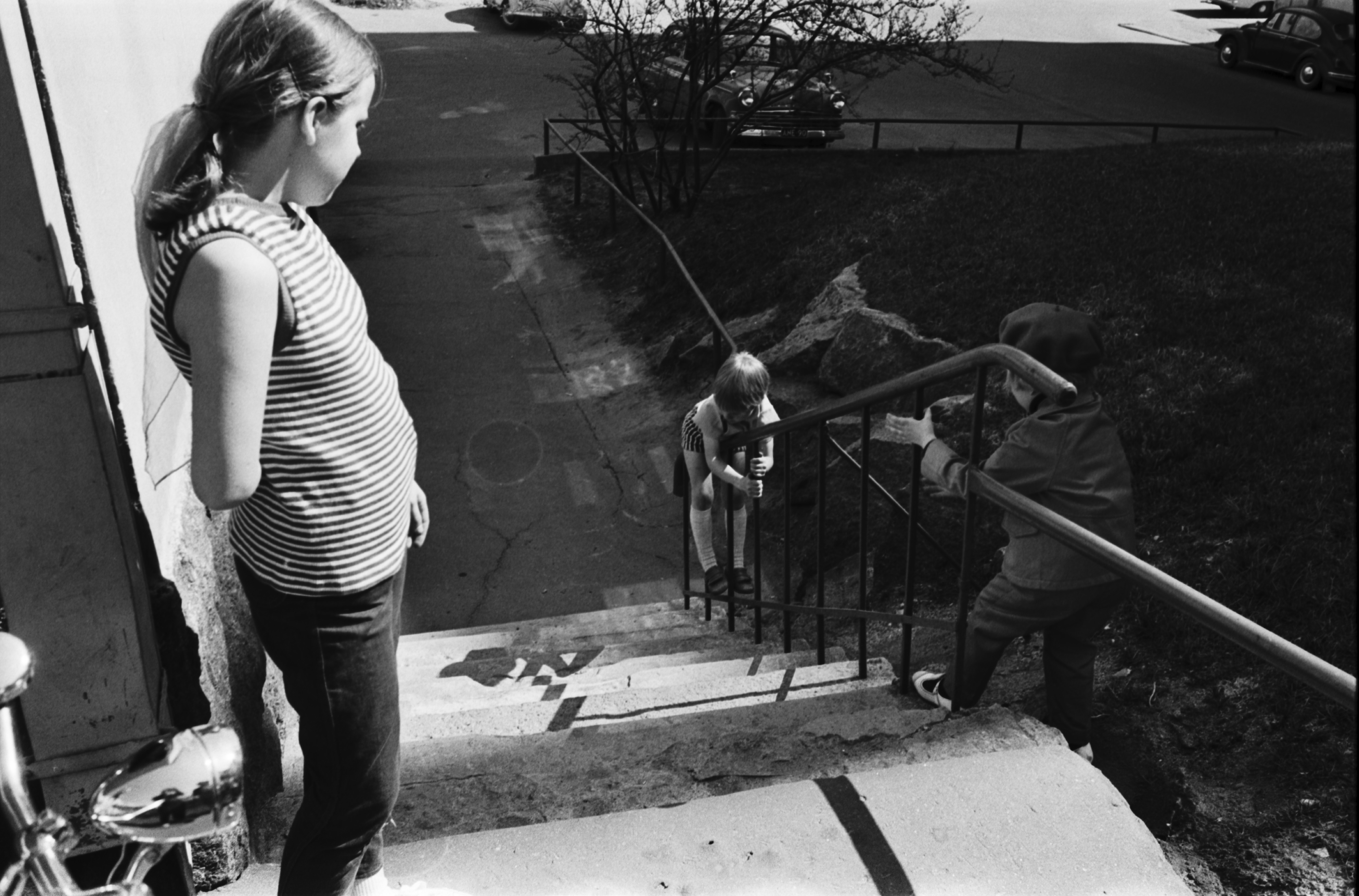 Torkkelinkatu 19. Lapsia liukumassa portaiden kaiteella Torkkelinkatu 19:n pihalla.