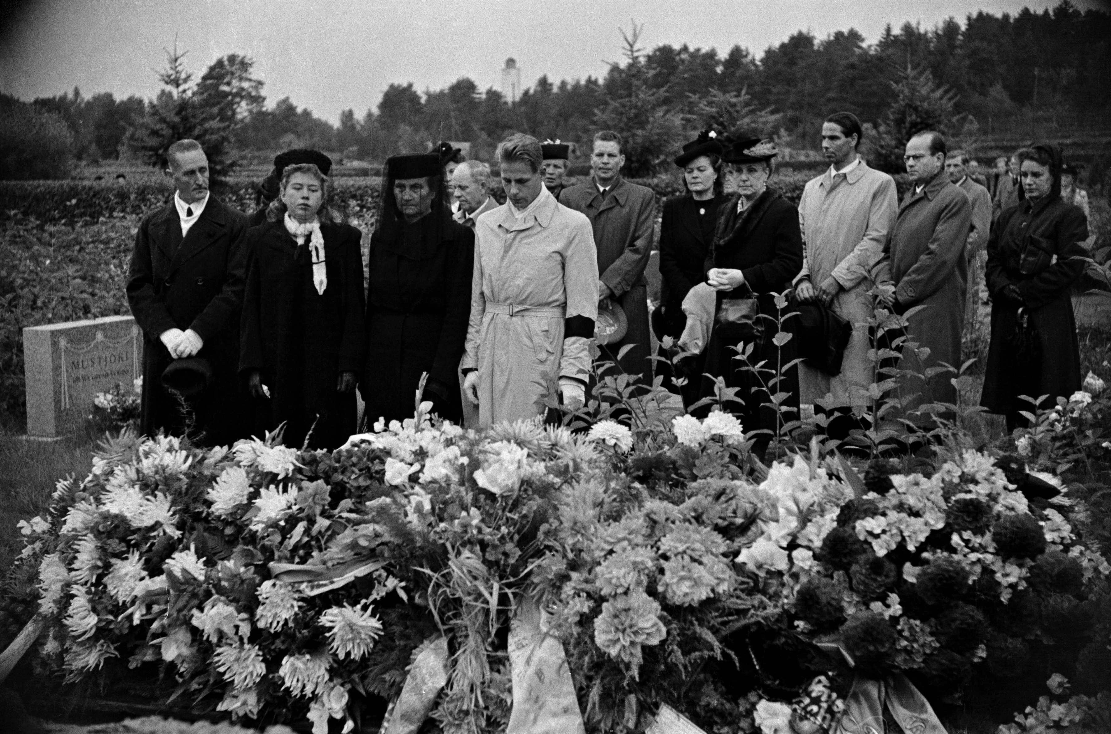 Anselm Lehtisen hautajaiset Pohjoisella hautausmaalla (=Malmin hautausmaa). Surevia omaisia kukitetun haudan äärellä, keskellä mies jolla käsivarressaan surunauha.