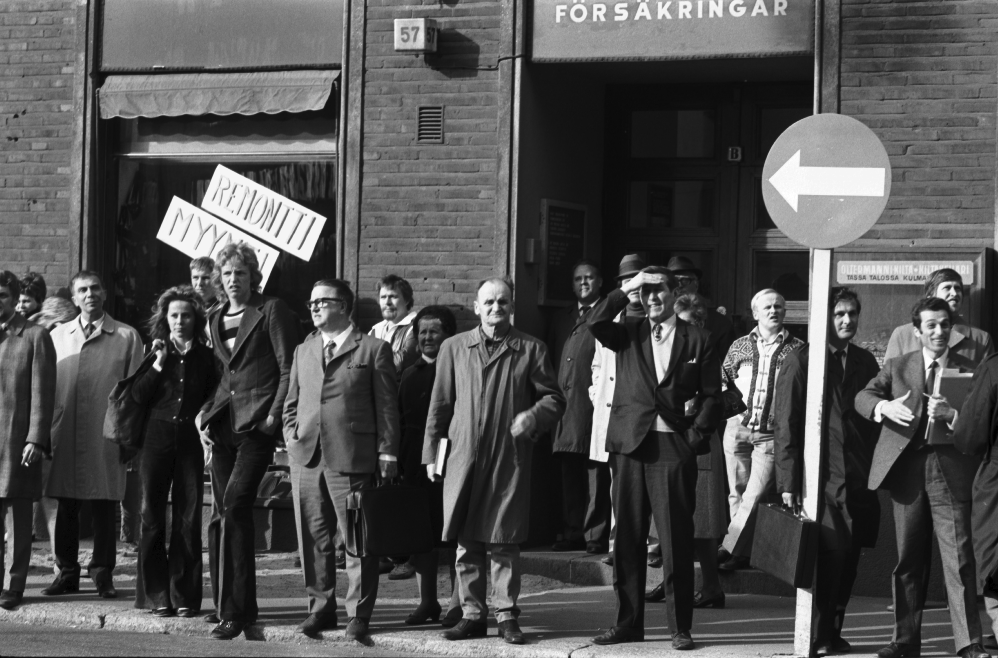 Ihmisiä seuraamassa sionismin vastaista mielenosoitusta Fredrikinkadulla Kansakoulukadun kulmassa.