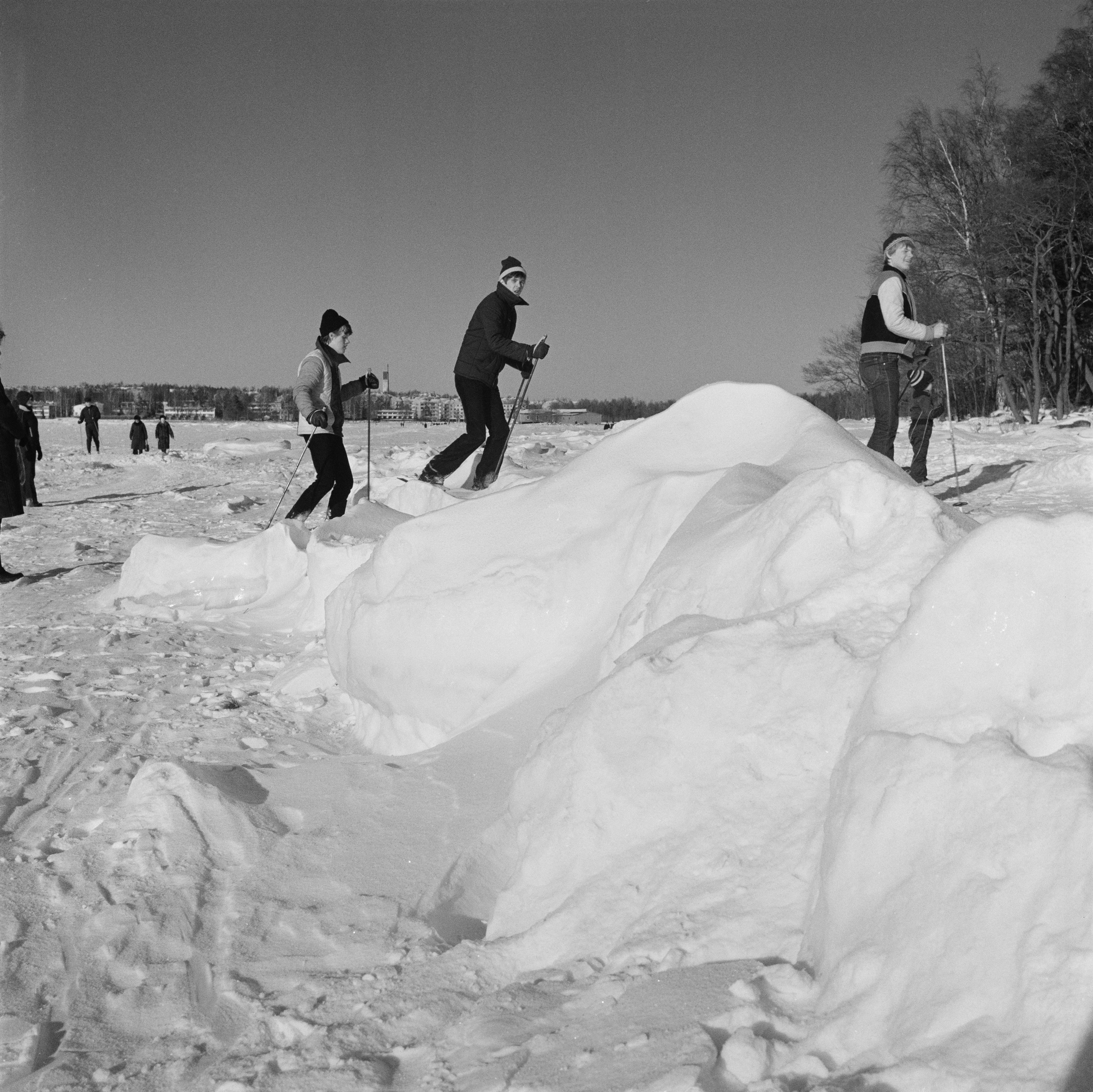 Hiihtäjiä ja jäällä kävelijöitä Länsilahdella Lauttasaaressa.