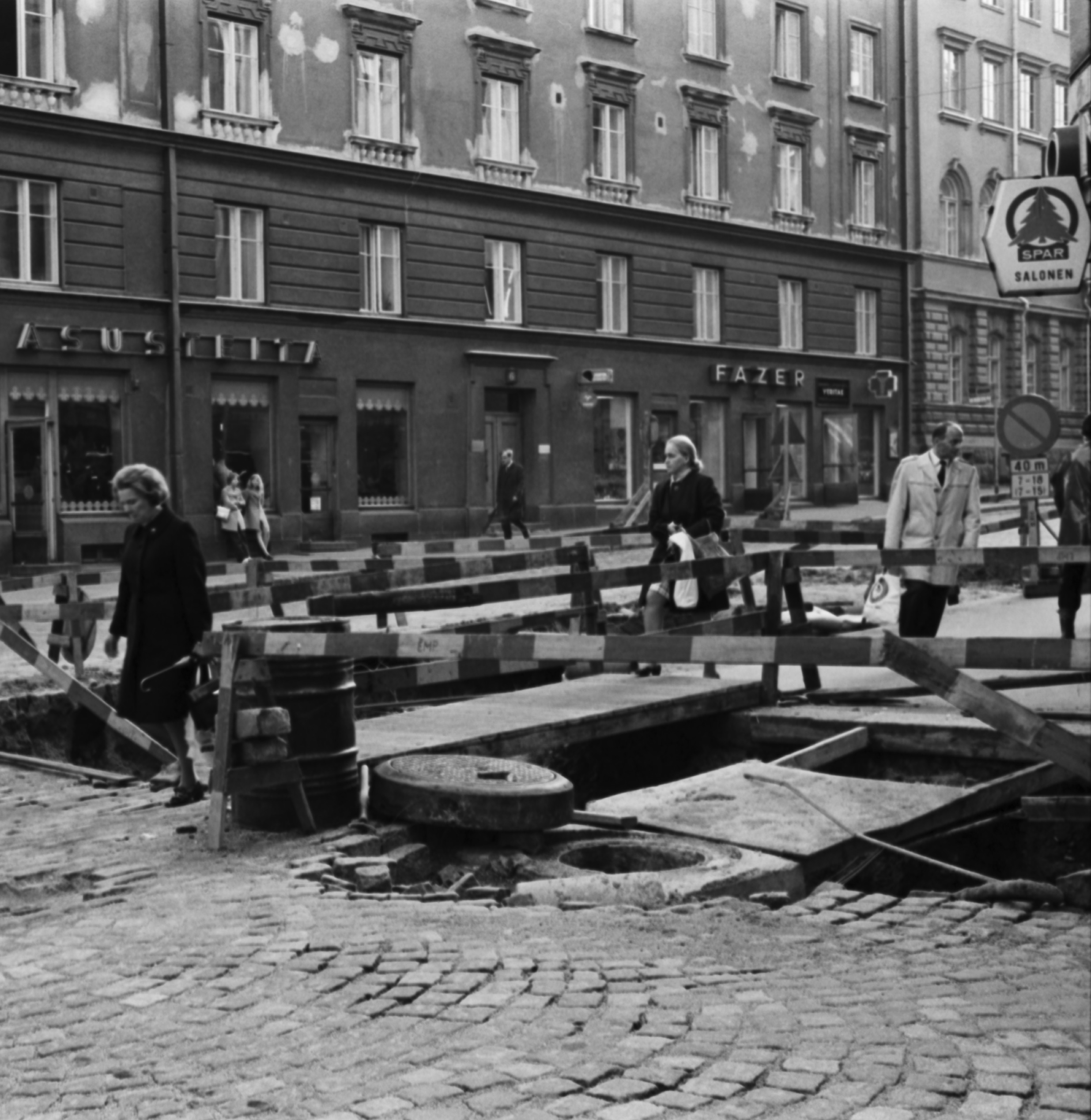 Liisankatu. Ihmisiä ylittämässä katua Liisankadun ja Meritullinkadun risteyksessä, jossa katutyömaa.