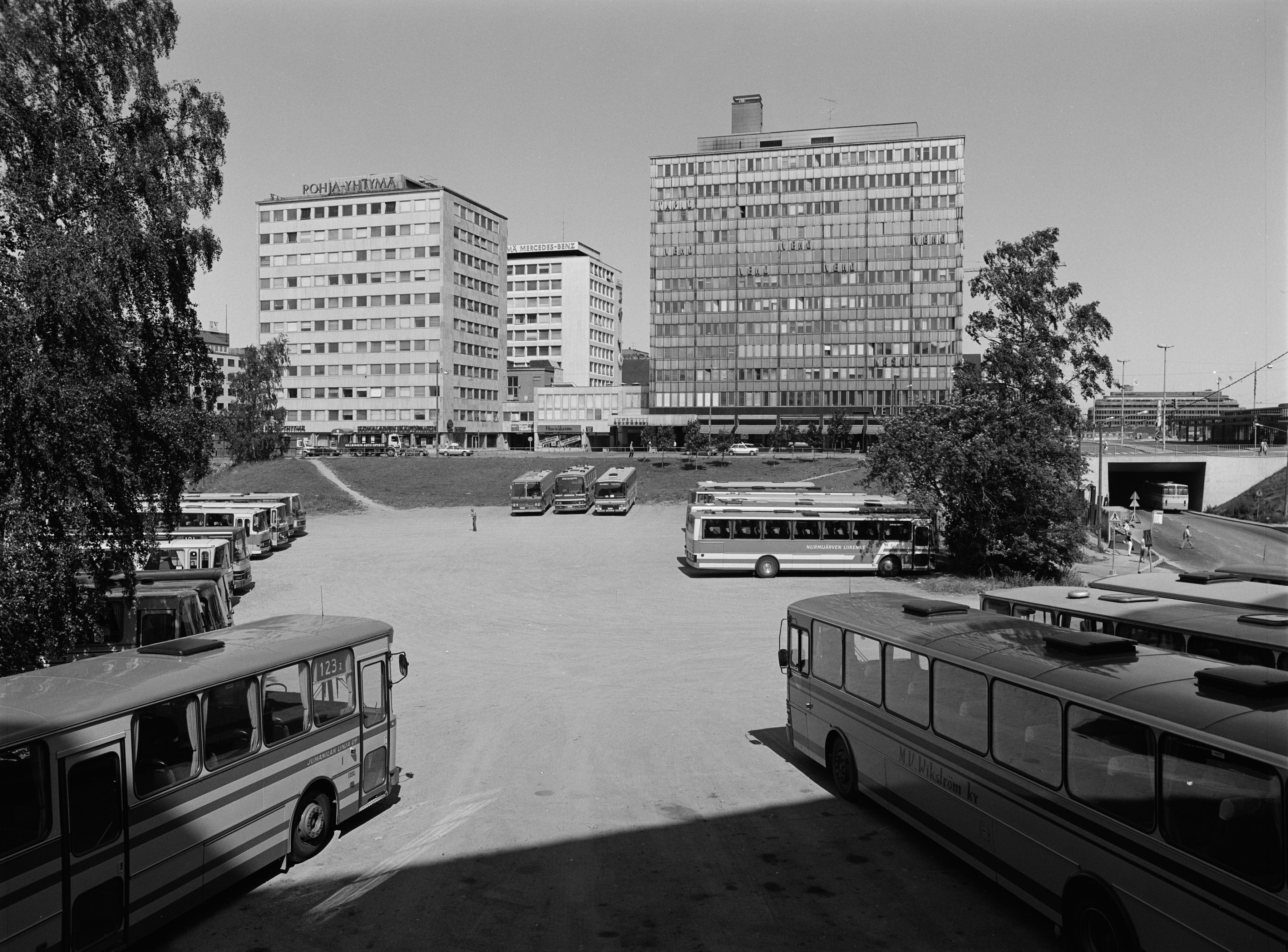Linja-autojen pysäköintialue Kampin kolmiossa, Malminkadun ja Runeberginkadun välissä.  Taustalla Salomonkatu 17, Runeberginkatu 5.