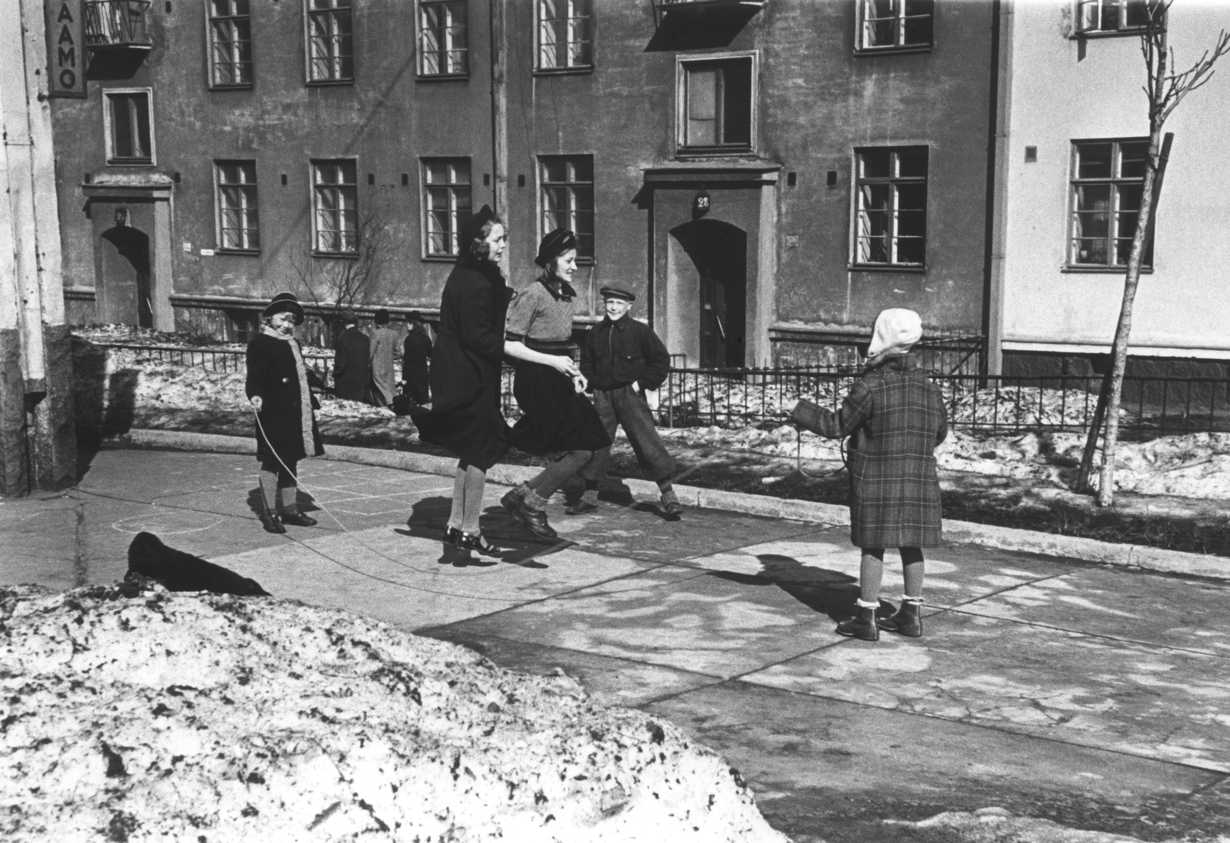 Lapsia hyppäämässä narua Torkkelinkatu 7:n pihalla taustalla Torkkelinkuja 28.