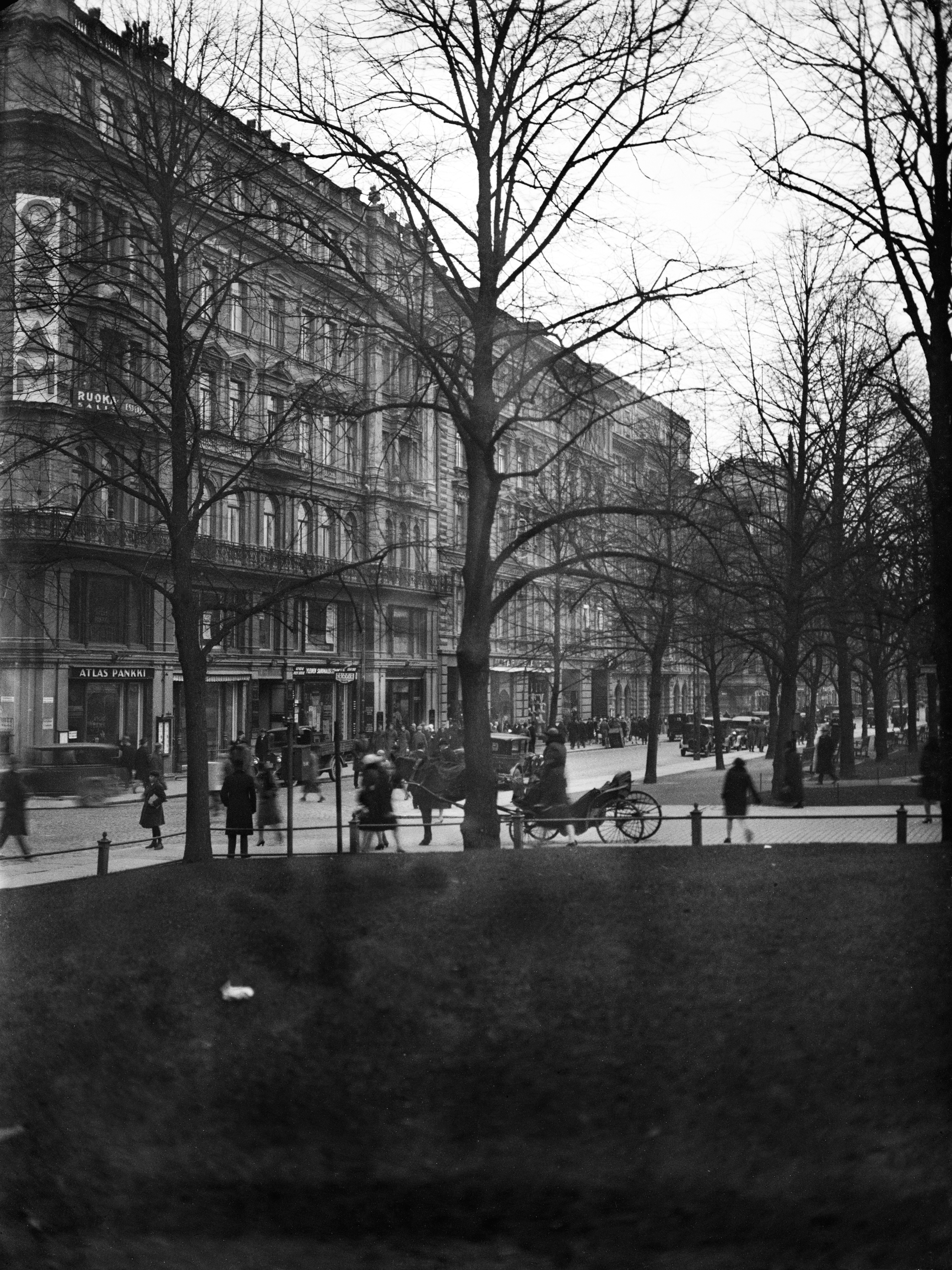 Pohjoisesplanadi 33 ja 31. Näkymä on puiston puolelta kadun yli. Kadulla autoja ja hevosrattaat.