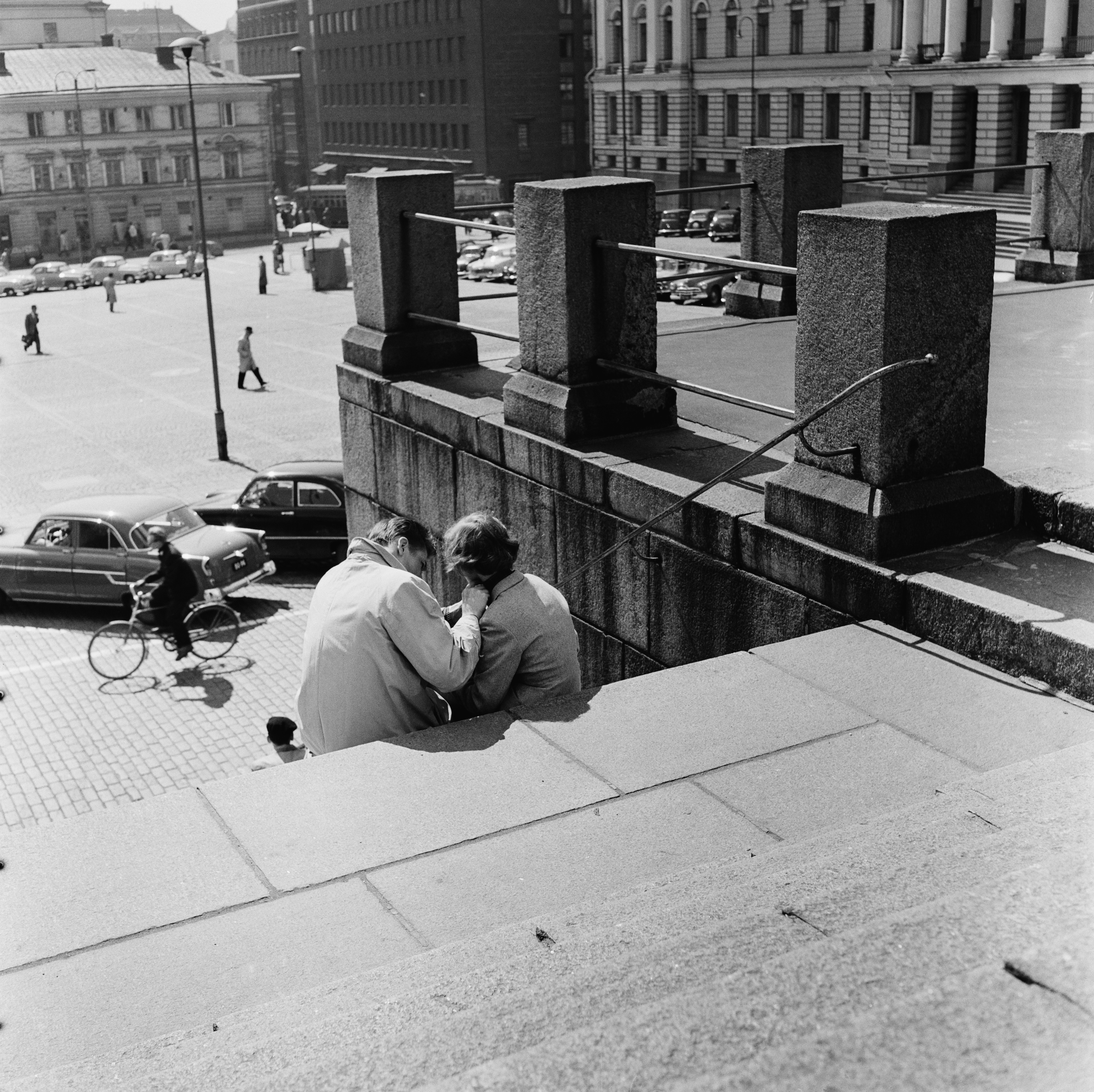 Nuoripari istuskelee Tuomiokirkon portailla.