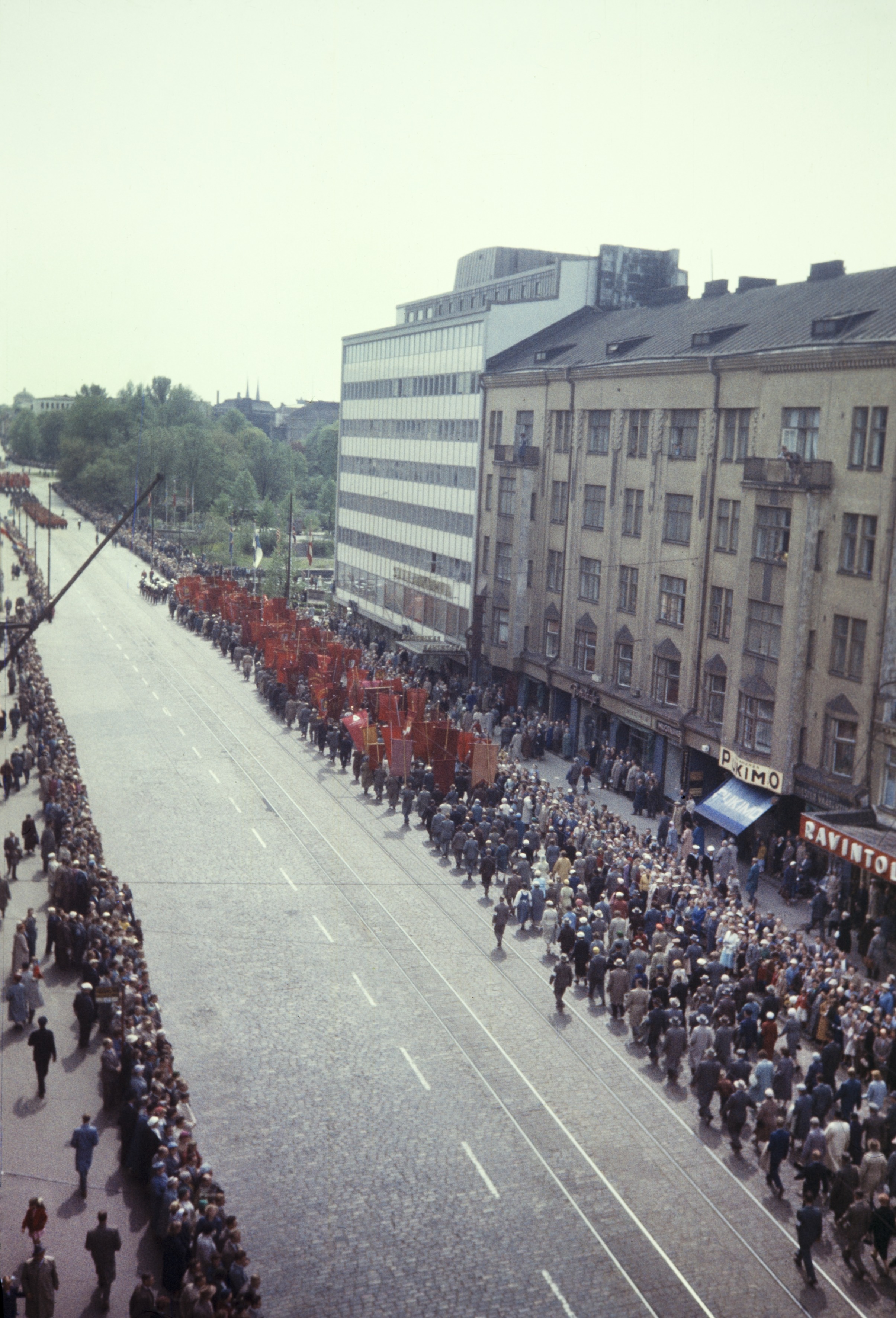 Elanto-lehti. Helluntai 1957, Siltasaarenkatu. Valtakunnallisen ammattiyhdistyslikkeen SAK:n  50-vuotisjuhla. Juhlakulkue marssi ammattiyhdistysliikkeiden lippujen johtamana viisitoistatuhantisena, juhlavana rivistönä läpi Helsingin. Pääjuhla pidettiin stadionilla.