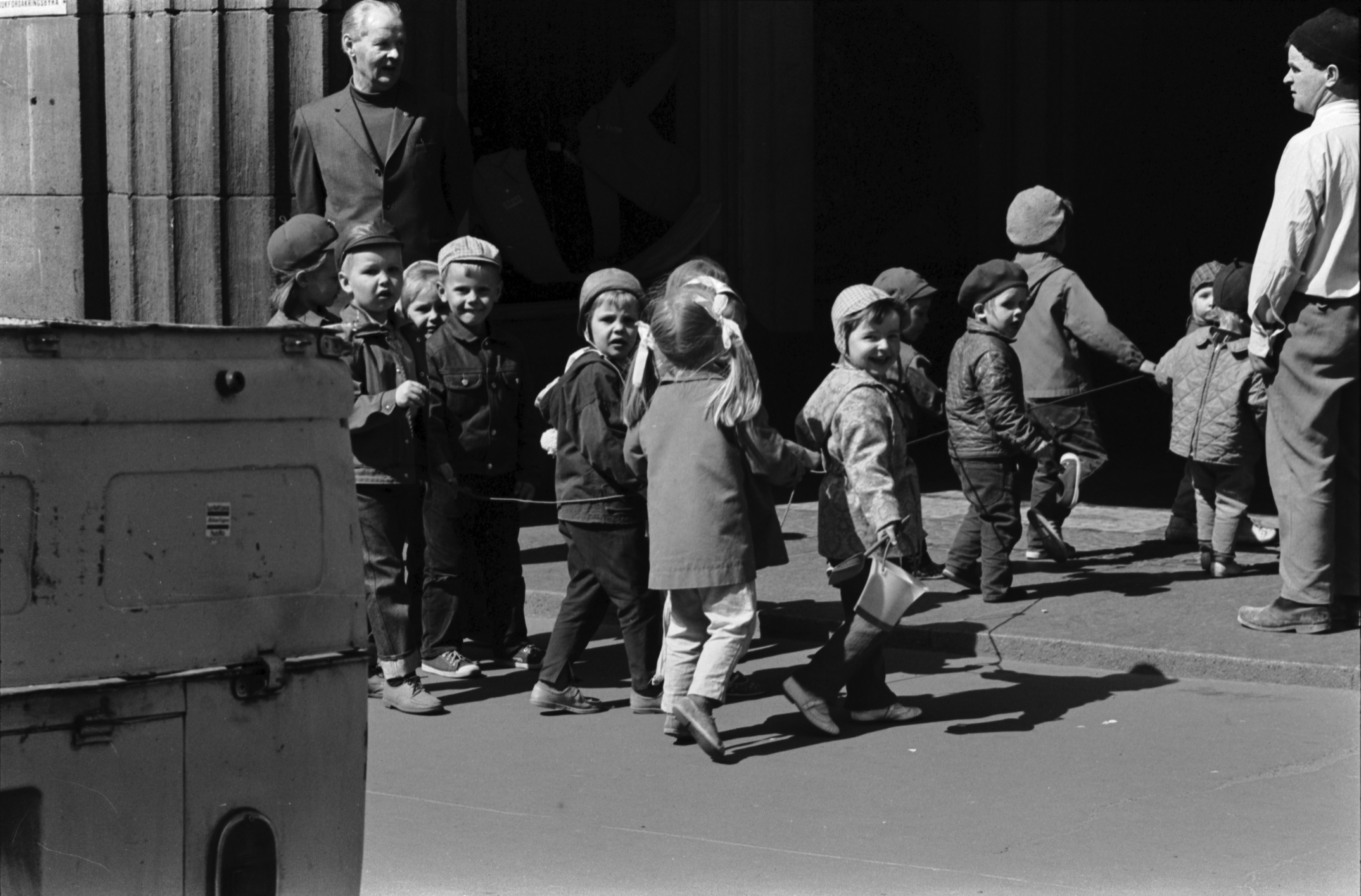 Hämeentie 8. Tokoinrannan puistosta tulevat lapset jonossa narusta kiinni pitäen menossa lastentarhan ovesta sisään.