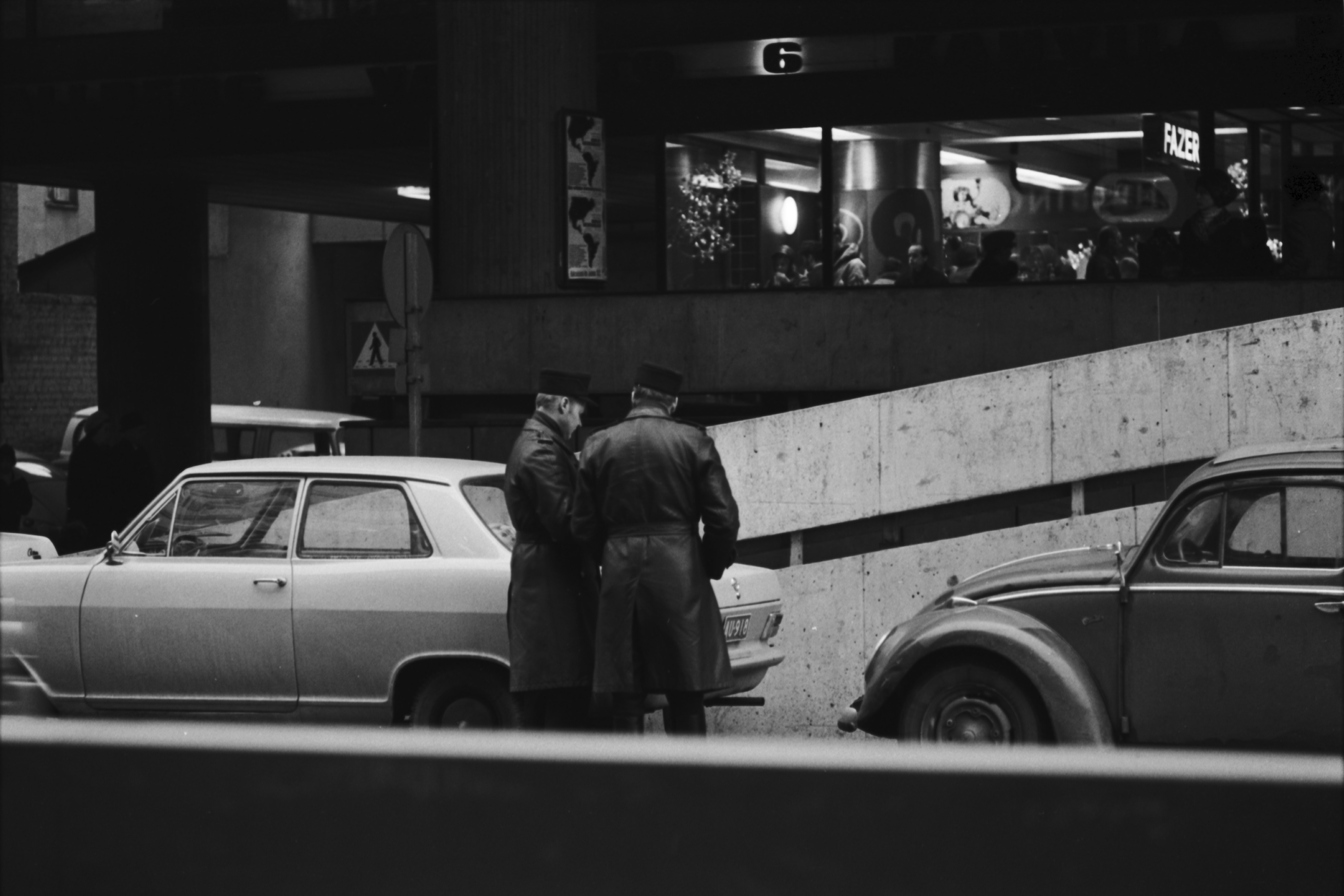 Kluuvi, Keskuskatu 6. Kaksi poliisia kirjoittamassa sakkolappuja pysäköidyille autoille (Opell Kadett, oikealla Volkswagen) Keskuskadulla Makkaratalon autoramppien luona.