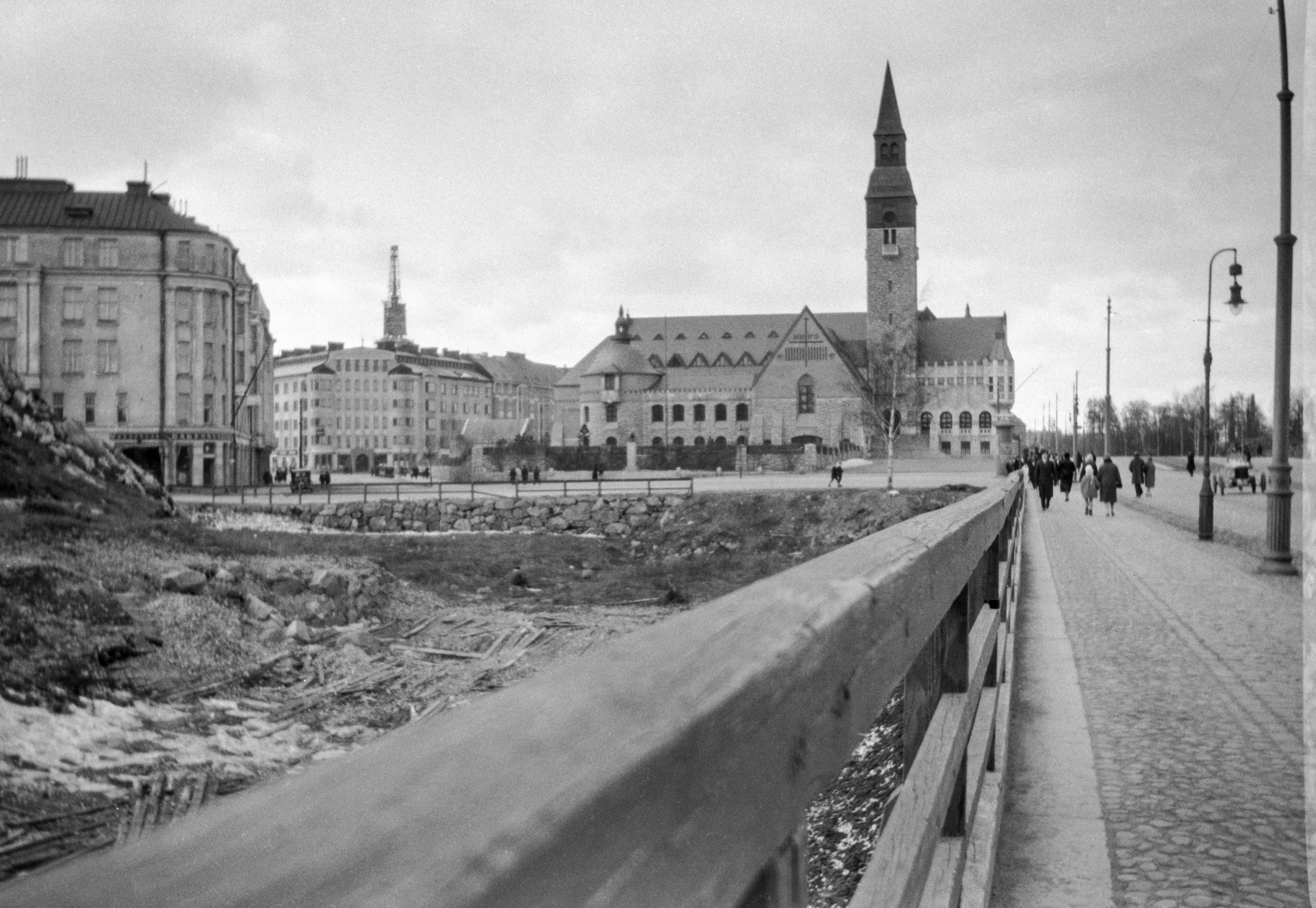 Läntinen viertotie 6 (Mannerheimintie), Kansallismuseo. Vasemmalla Aurorankatu 3 - Museokatu 8. Taustalla Museokatu 1, Töölönkatu 6 sekä Kristuskyrkanin torni. Jalankulkijoita mukulakivikadulla.