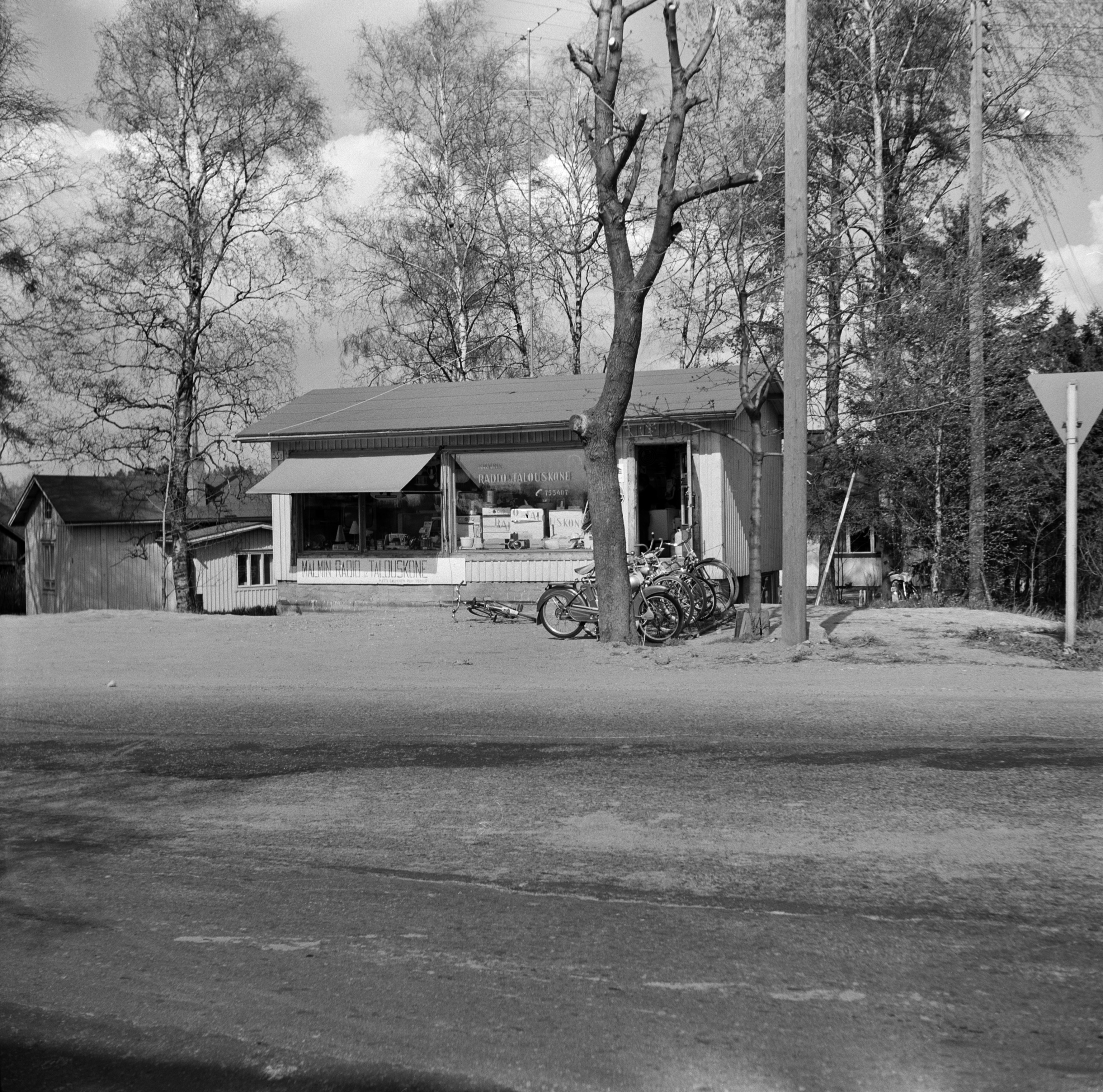 Malmin Radio ja Talouskoneen liike, Kirkonkyläntie 35, Malmi. Liikkeen omistaja Matti Salminen asui oikealla kaupan takana pilkistävässä omakotitalossa.